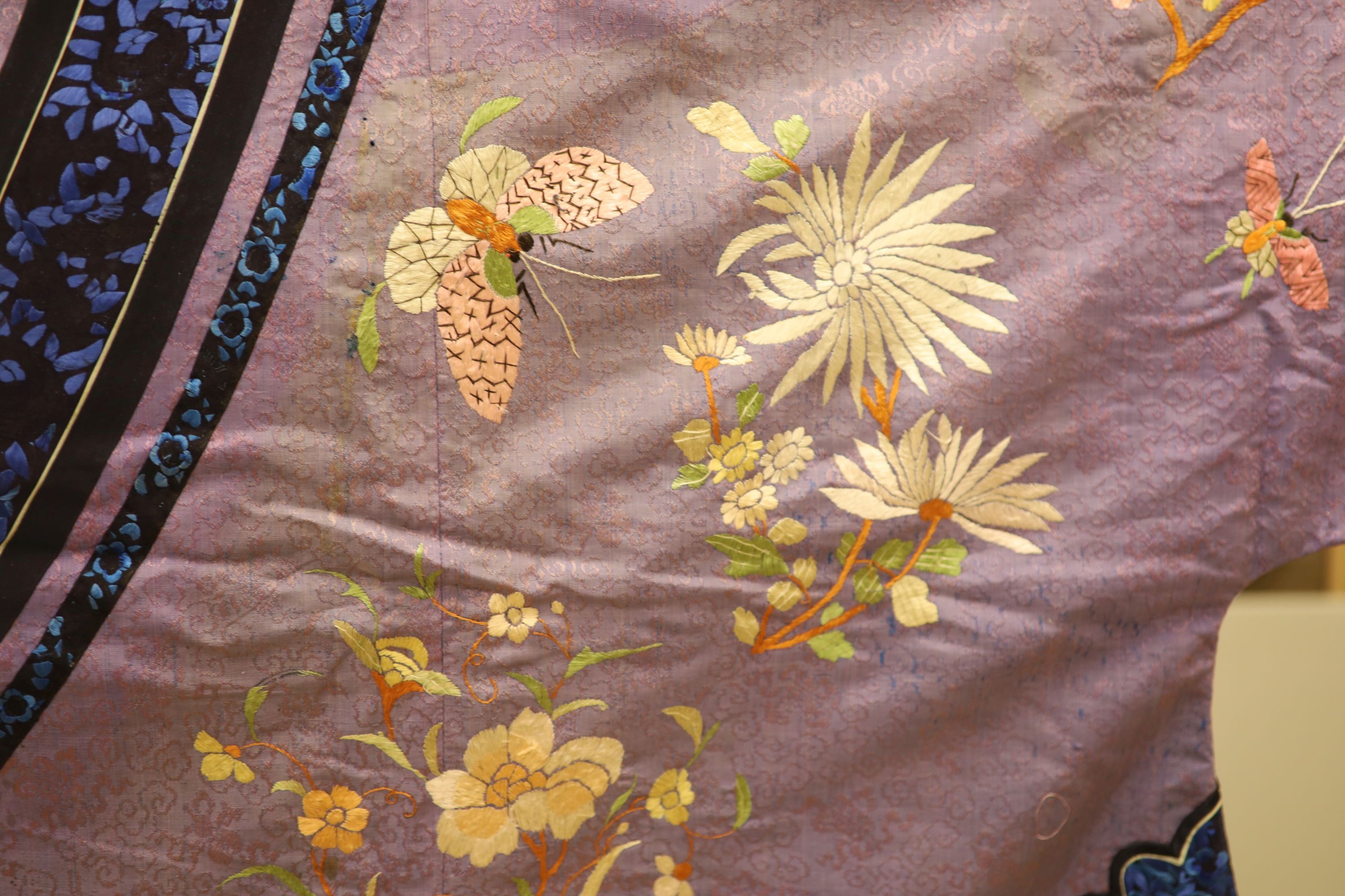 A Chinese lilac silk embroidered robe, early 20th century with multi-coloured embroidery and wide embroidered sleeve bands,